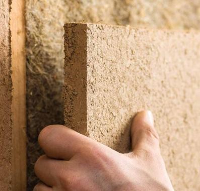 Lehmbauplatte mit Lehmputz, Hand zeigt die Materialstärke