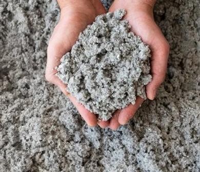 Zellulosedämmung aus recyceltem Altpapier in zwei Händen